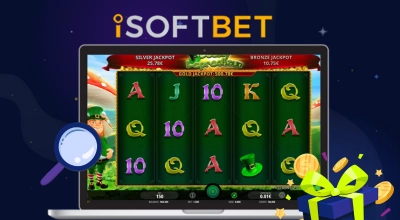 A laptop displaying an iSOFTBET slot game with a magnifying glass and a gift.