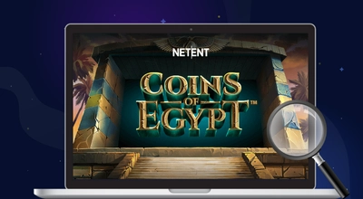 Coins of Egypt logo on a laptop with a magnifying glass against a dark setting.