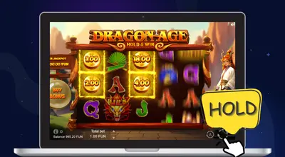Laptop showing Dragon Age Hold & Win gameplay with cursor on spin button with a HOLD bubble.