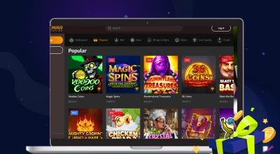 Un ordinateur portable affiche le lobby de jeux de Hugo Casino avec une sélection de titres populaires de machines à sous et une icône de cadeau.